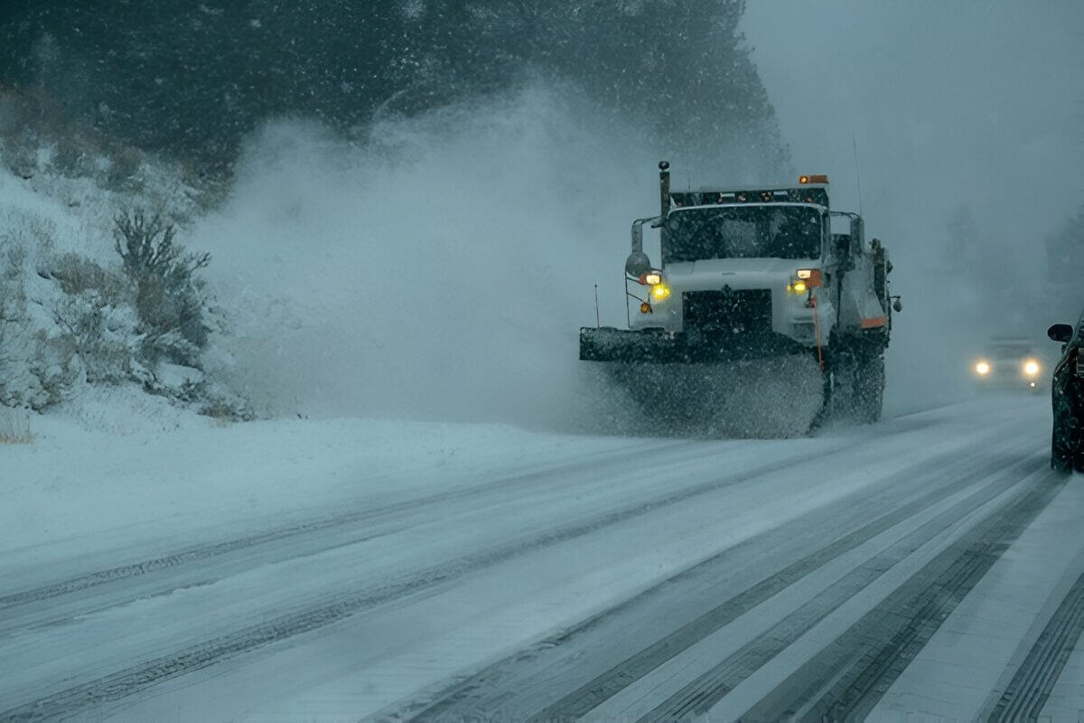 Snowplow clearing thick snow on a mountain road in winter.